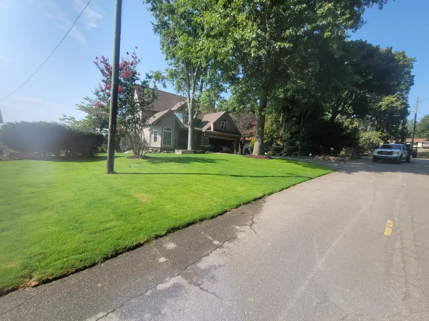 Street view of a healthy edged lawn maintained by T.E. Lawn Service
