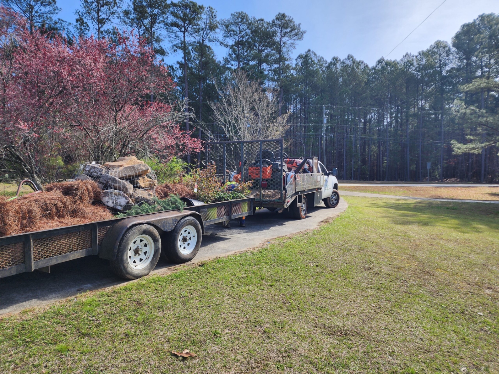 T.E. equipment and hauling trailer loaded with materials and plants