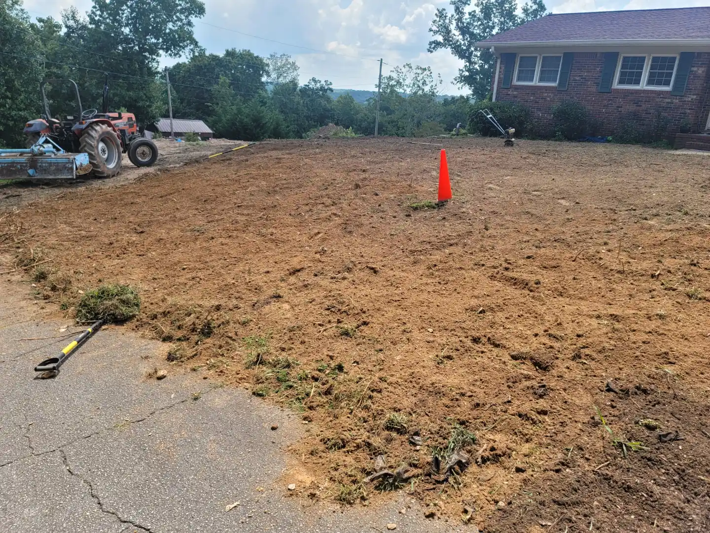Tractor tilling and grading a front yard for new lawn installation